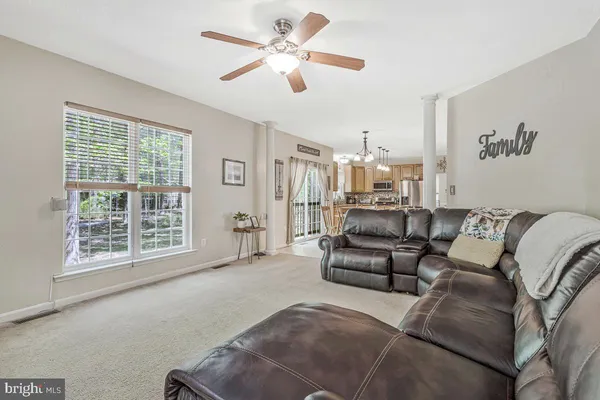 a kitchen with stainless steel appliances granite countertop a refrigerator a sink dishwasher a stove a dining table and chairs with wooden floor