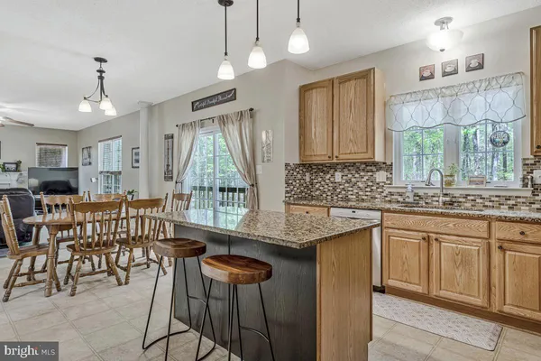 a kitchen with stainless steel appliances granite countertop a refrigerator sink stove microwave and cabinets