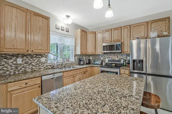 a dining room with furniture a chandelier and kitchen view