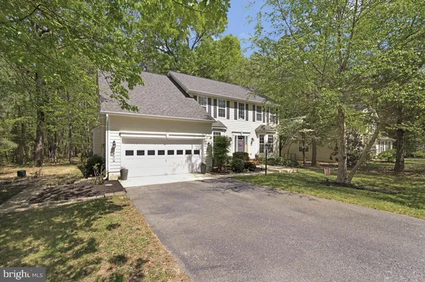 a front view of a house with a yard and potted plants