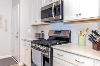4268 Coachwhip Avenue, Unit 92 Lancaster, SC 29720 - Photo 12 of 36 a kitchen with stainless steel appliances granite countertop a stove and a microwave