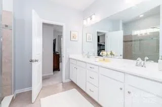a spacious bathroom with double sink and a mirror