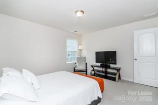 4268 Coachwhip Avenue, Unit 92 Lancaster, SC 29720 - Photo 26 of 36 a bedroom with a bed and a flat screen tv