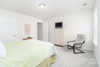 a bedroom with a bed chair and glass window