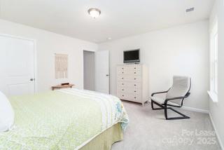 4268 Coachwhip Avenue, Unit 92 Lancaster, SC 29720 - Photo 28 of 36 a bedroom with a bed chair and glass window