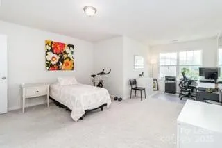 a spacious bedroom with a bed a table and a large window