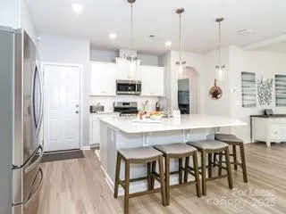a kitchen with kitchen island a dining table chairs sink and cabinets