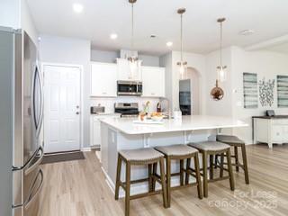 4268 Coachwhip Avenue, Unit 92 Lancaster, SC 29720 - Photo 10 of 36 a kitchen with kitchen island a dining table chairs sink and cabinets