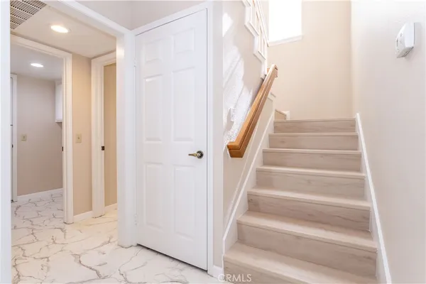 a view of an empty room with wooden floor and closet