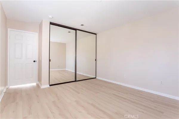 an empty room with wooden floor and sliding door