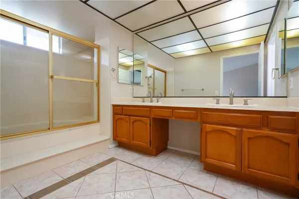 a spacious bathroom with a mirror a sink and shower