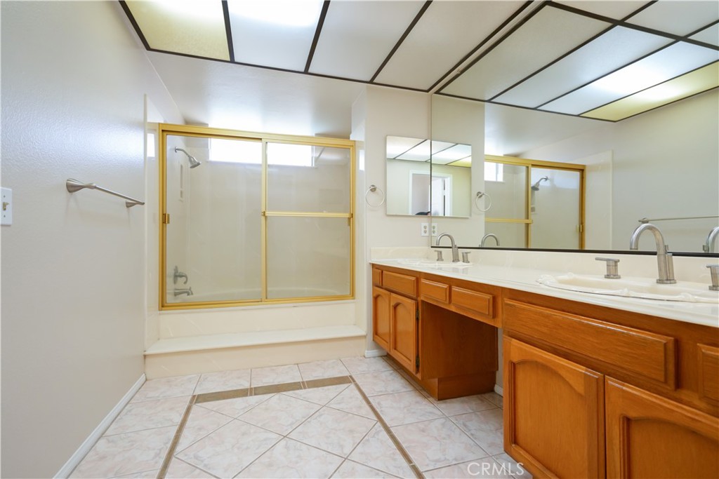 12067 Turtle Springs Court Porter Ranch, CA 91326 - Photo 24 of 34 a spacious bathroom with a mirror a sink and shower