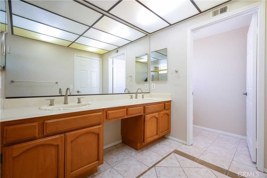 12067 Turtle Springs Court Porter Ranch, CA 91326 - Photo 26 of 34 a spacious bathroom with a double vanity sink and a mirror
