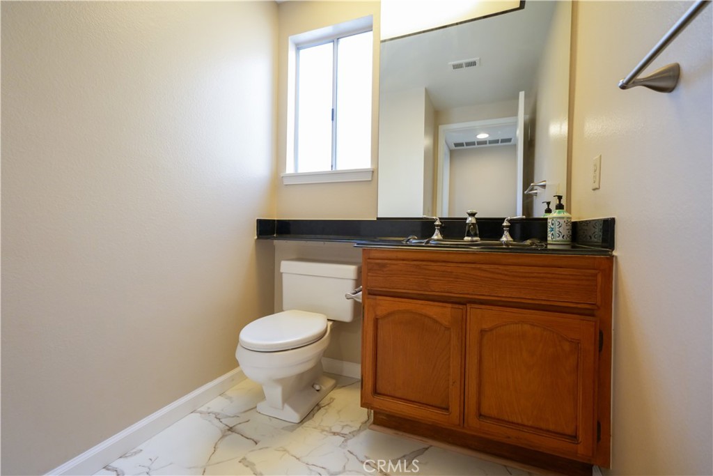 12067 Turtle Springs Court Porter Ranch, CA 91326 - Photo 27 of 34 a bathroom with a granite countertop toilet a sink and a mirror