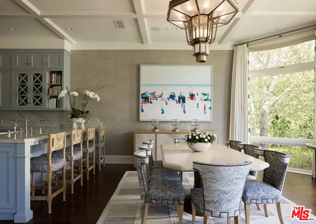a dining room with furniture a large window and wooden floor