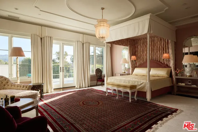 a bedroom with a bed mirror and a window