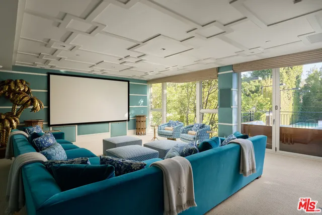 a media room with lots of windows and a chandelier