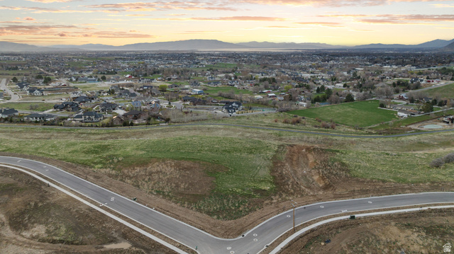 2042 Valley Drive, Unit 57 Mapleton, UT 84664 - Photo 13 of 18 Expansive undeveloped land featuring a paved road with concrete sidewalks, established infrastructure, and distant residential areas