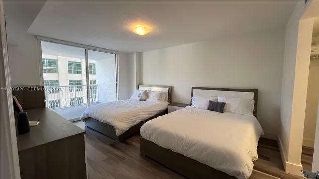 a bedroom with furniture and a large window