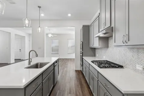 a kitchen with stainless steel appliances granite countertop a sink stove and cabinets