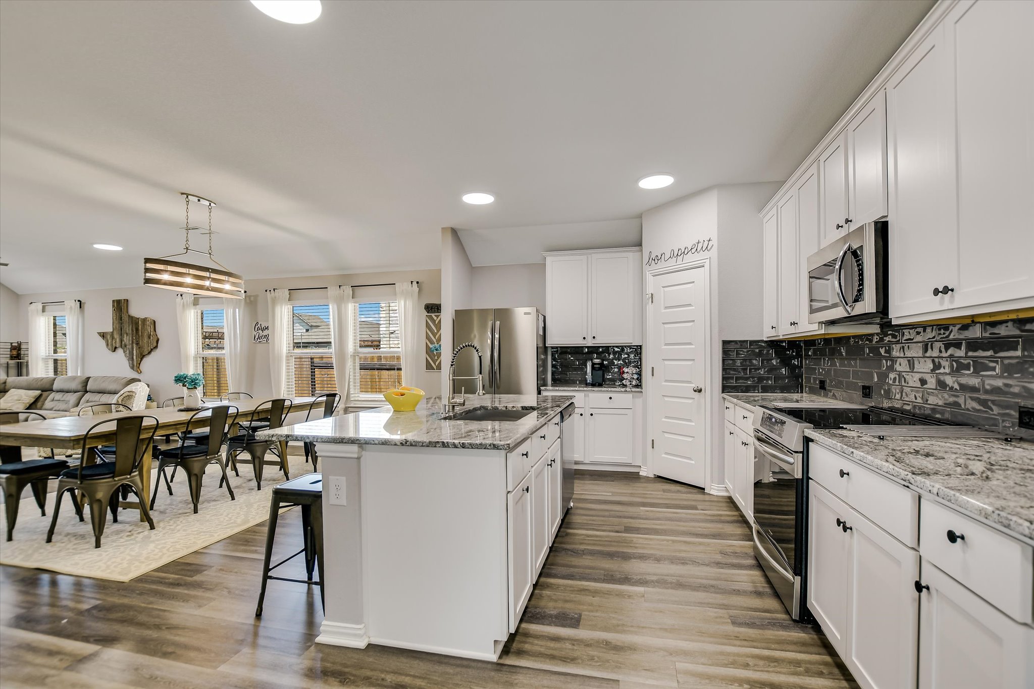 1101 Terrace View Drive Georgetown, TX 78628 - Photo 19 of 20 a large kitchen with white cabinets a sink a stove a dining table and chairs
