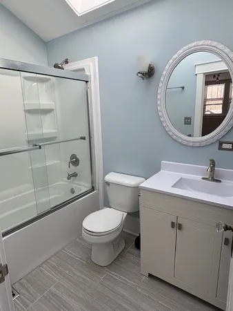a bathroom with a sink toilet a mirror and shower