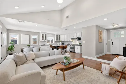 a living room with furniture kitchen view and a window