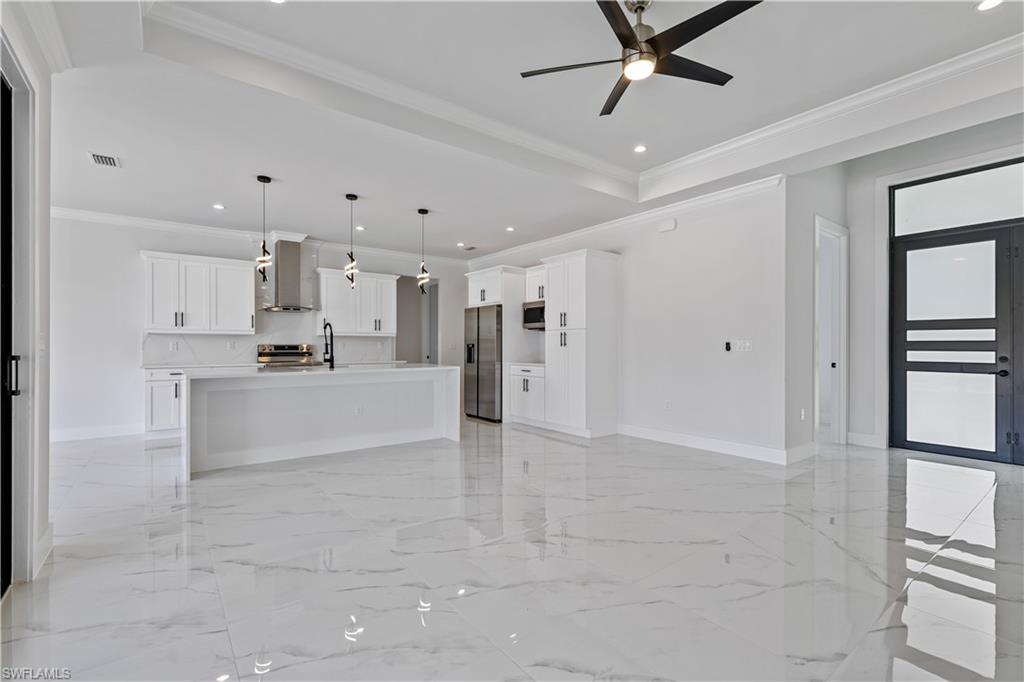 3397 14th Avenue Southeast Naples, FL 34117 - Photo 11 of 28 a large white kitchen with kitchen island stainless steel appliances cabinets and a counter top space