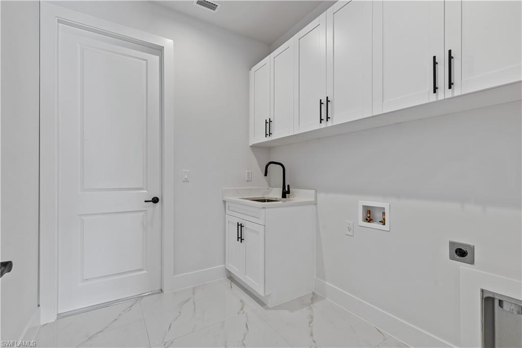 3397 14th Avenue Southeast Naples, FL 34117 - Photo 17 of 28 a kitchen with white cabinets and sink