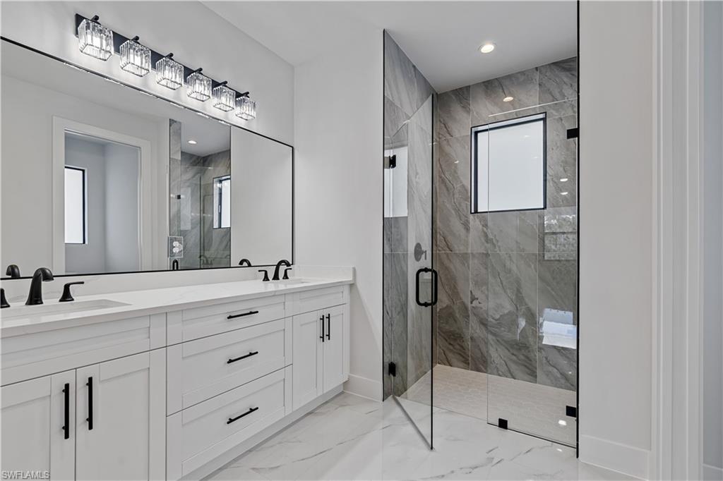 3397 14th Avenue Southeast Naples, FL 34117 - Photo 24 of 28 a bathroom with a shower sink and mirror