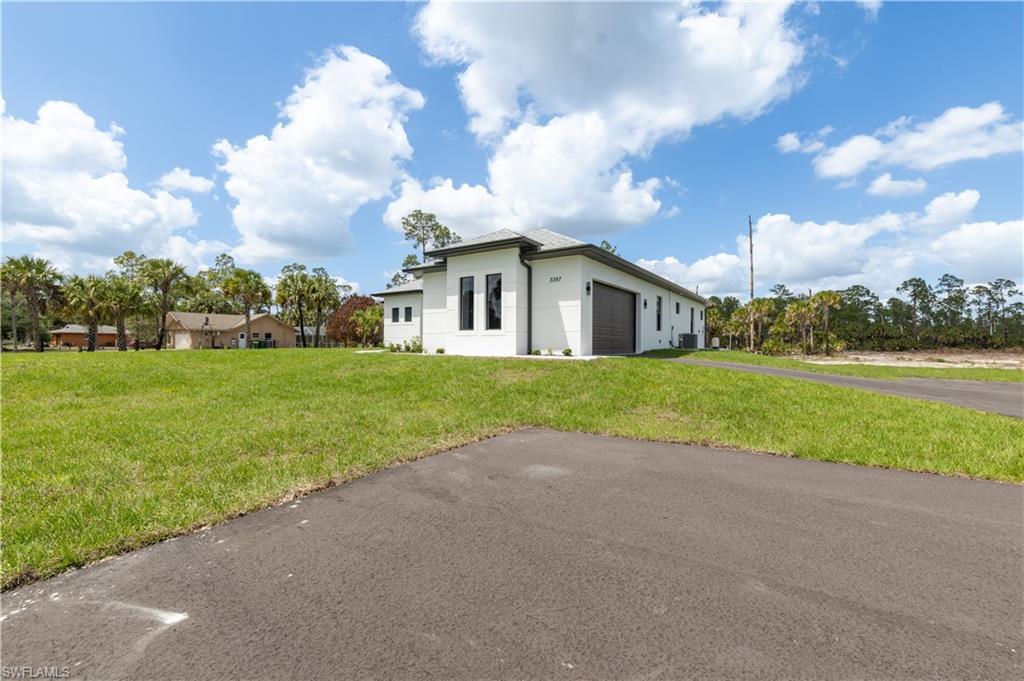 3397 14th Avenue Southeast Naples, FL 34117 - Photo 7 of 28 a view of a house with a big yard and potted plants