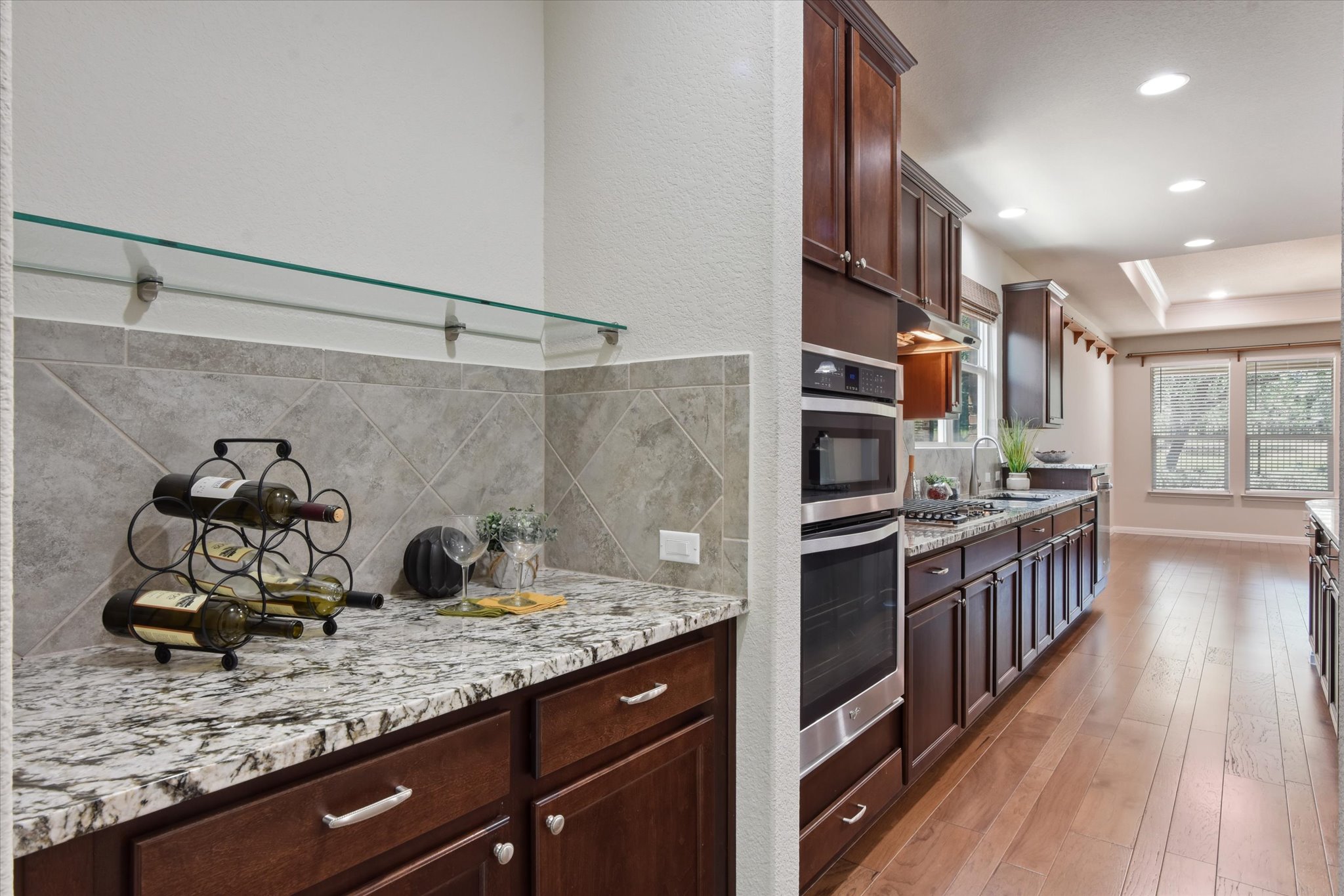 104 Coffee Mill Creek Road Georgetown, TX 78633 - Photo 7 of 40 Convenient wet bar with granite countertop and glass shelving, ideally located between the flex room and kitchen for entertaining.