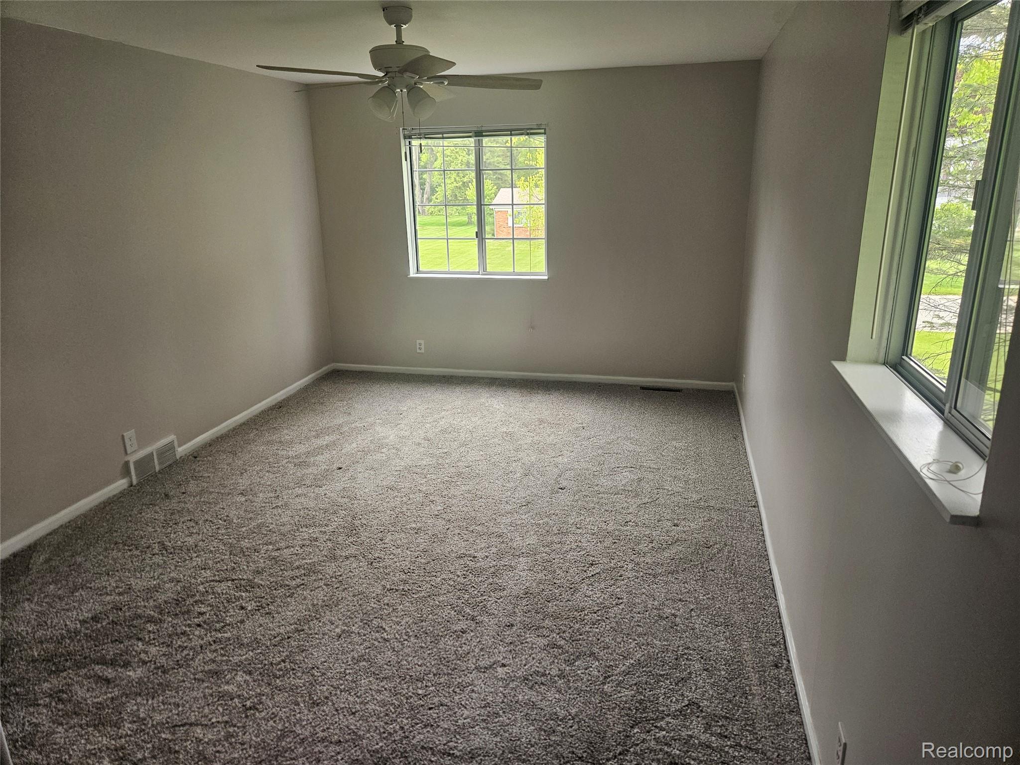 1210 Bay Ridge Drive Highland, MI 48356 - Photo 10 of 25 Empty room featuring ceiling fan and carpet flooring