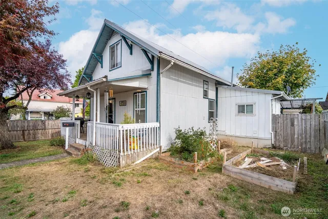 a white house that has tree in front of it
