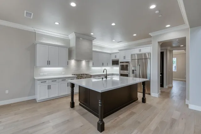 a kitchen with kitchen island stainless steel appliances a sink and a refrigerator