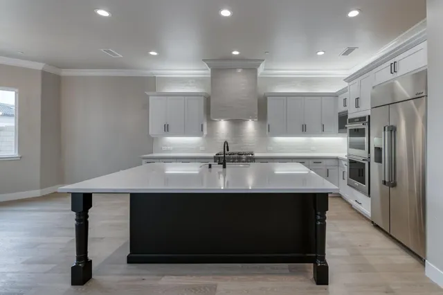 a kitchen with stainless steel appliances granite countertop a sink stove and refrigerator
