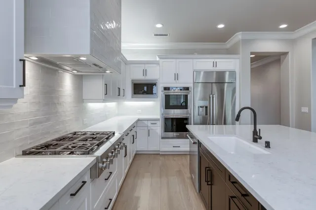 a kitchen with stainless steel appliances kitchen island a white stove top oven and sink