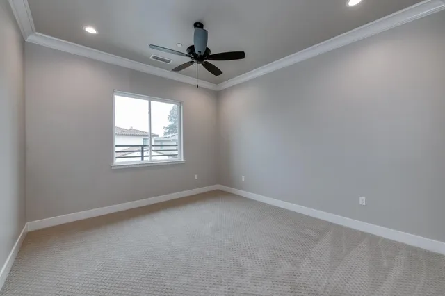 an empty room with a window and a fan