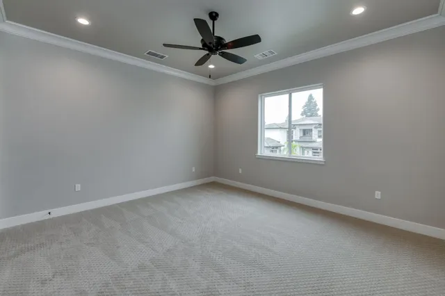 en empty room with windows and ceiling fan