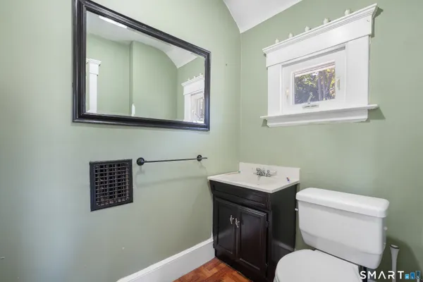 a bathroom with a toilet a sink and mirror