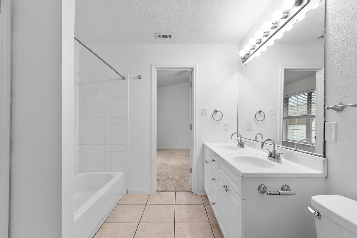 2602 Peach Tree Lane Cedar Park, TX 78613 - Photo 12 of 16 a spacious bathroom with a double vanity sink a mirror and a bathtub
