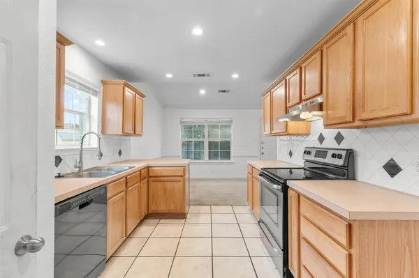 a kitchen with stainless steel appliances granite countertop a sink and a stove