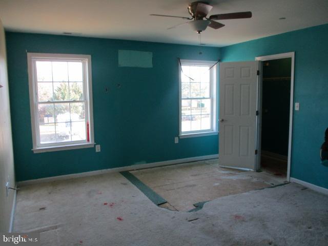 3102 Roger Road Baltimore, MD 21219 - Photo 12 of 16 an empty room with a window and a ceiling fan