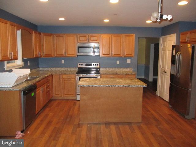 3102 Roger Road Baltimore, MD 21219 - Photo 6 of 16 a large kitchen with stainless steel appliances granite countertop a stove a refrigerator a sink dishwasher and wooden cabinets with wooden floor