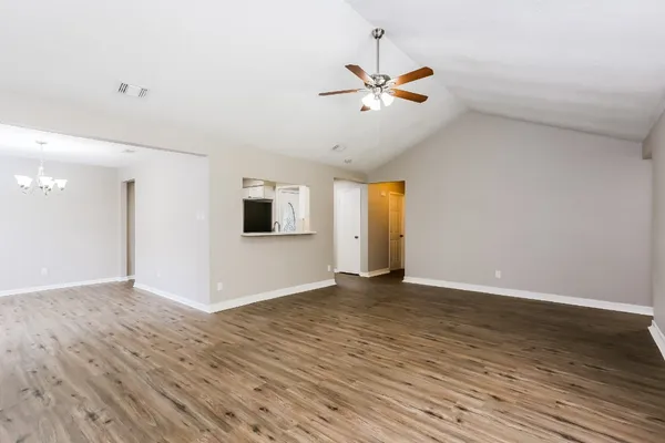 a view of an empty room with wooden floor