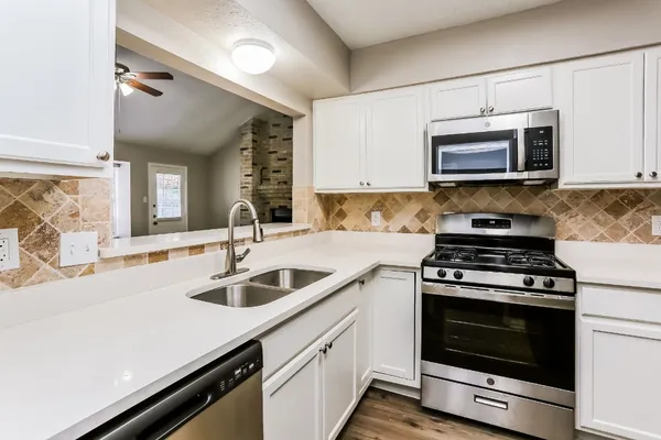a kitchen with stainless steel appliances granite countertop a sink stove and microwave