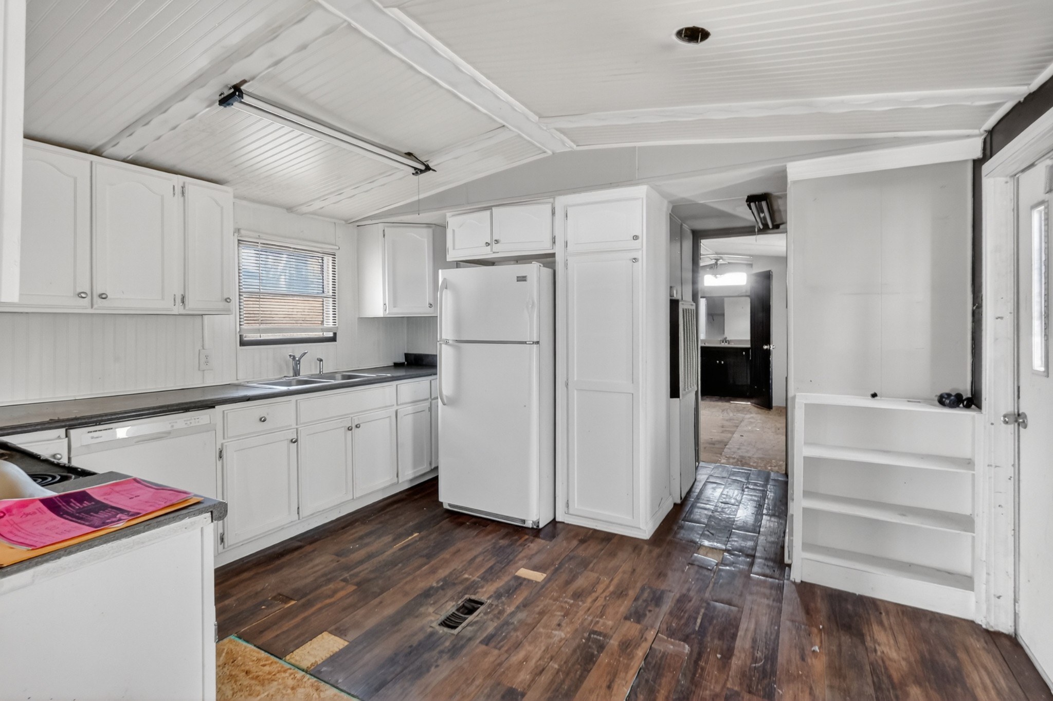 285 George Akins Road Westmoreland, TN 37186 - Photo 7 of 26 a kitchen with wooden floors and white cabinets