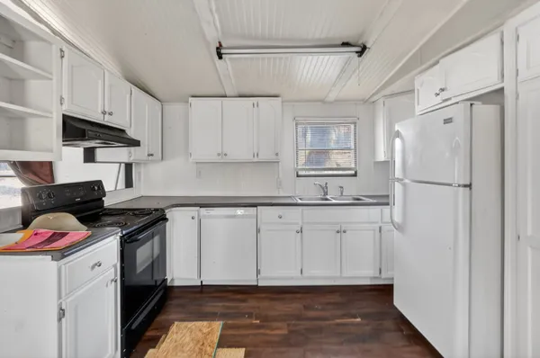 a kitchen with white cabinets and white appliances