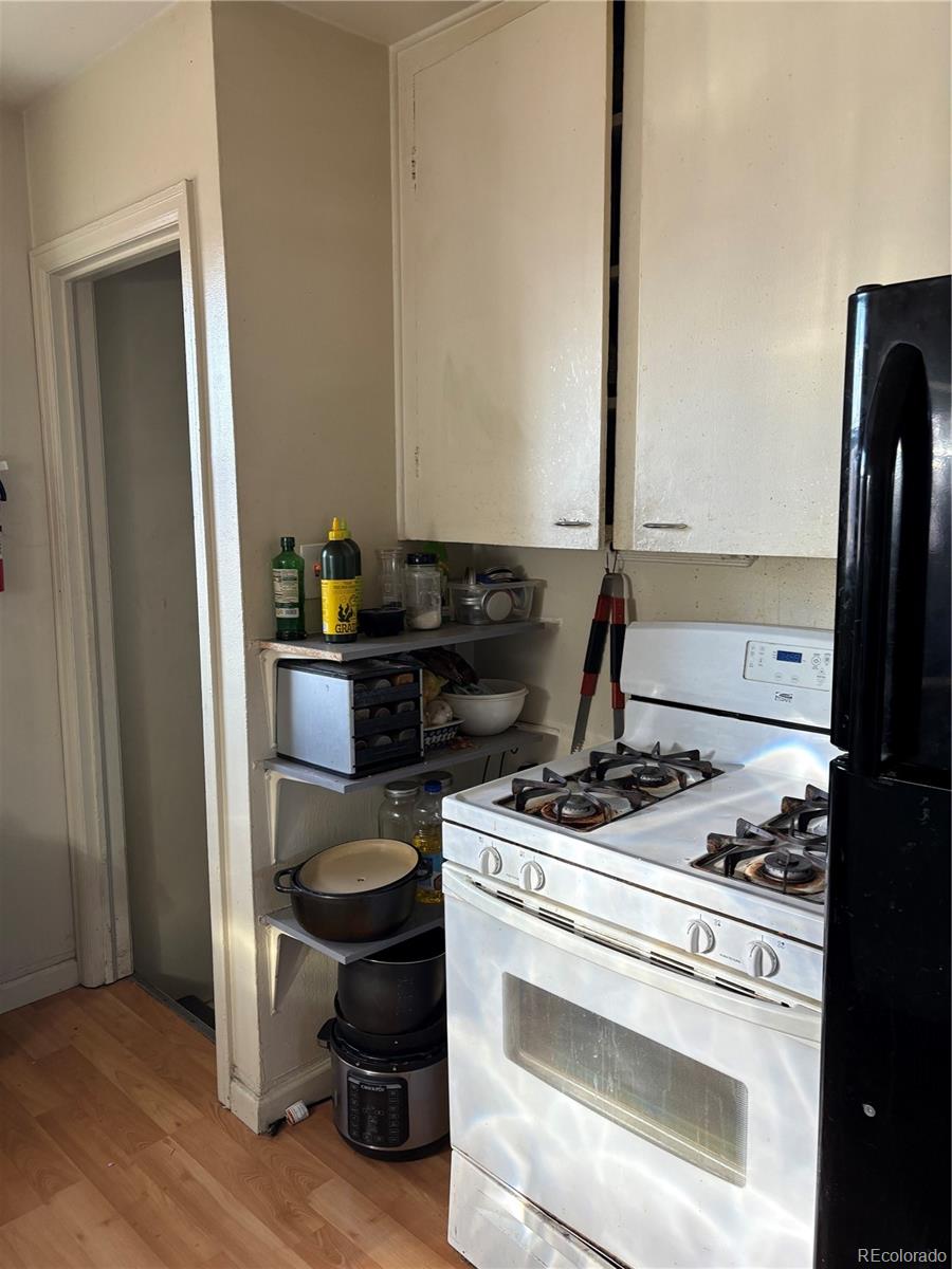 3349 Adams Street Denver, CO 80205 - Photo 28 of 31 a kitchen with a stove and a refrigerator