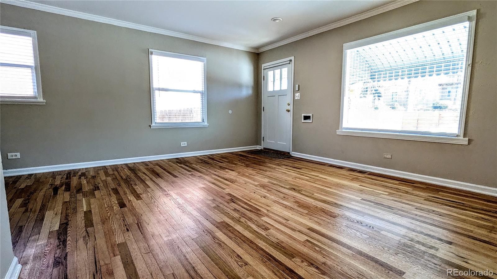 3349 Adams Street Denver, CO 80205 - Photo 4 of 31 a view of an empty room with wooden floor and a window